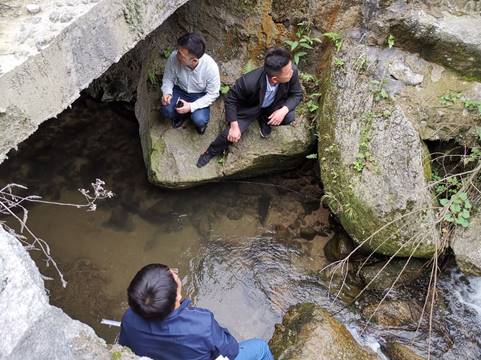 A group of people sitting on a rockDescription automatically generated